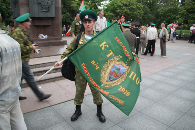 Ветеран-пограничник с флагом Находкинского пограничного отряда КТПО